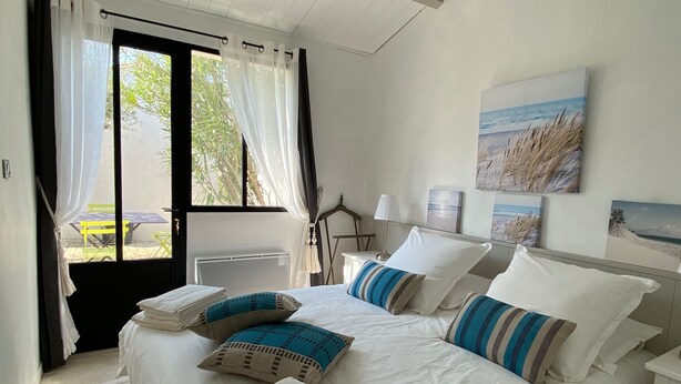 Una habitación de hotel con cama, mesa, sillas y vistas al exterior.