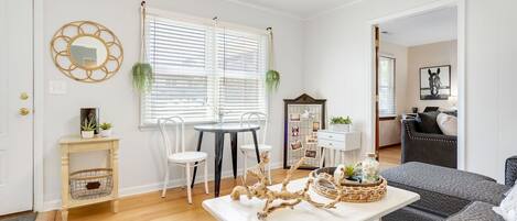 Una sala de estar bien iluminada con comedor, un sofá y una mesa de centro.