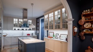 Una cocina moderna con una isla central, armarios de madera y un ventanal grande.