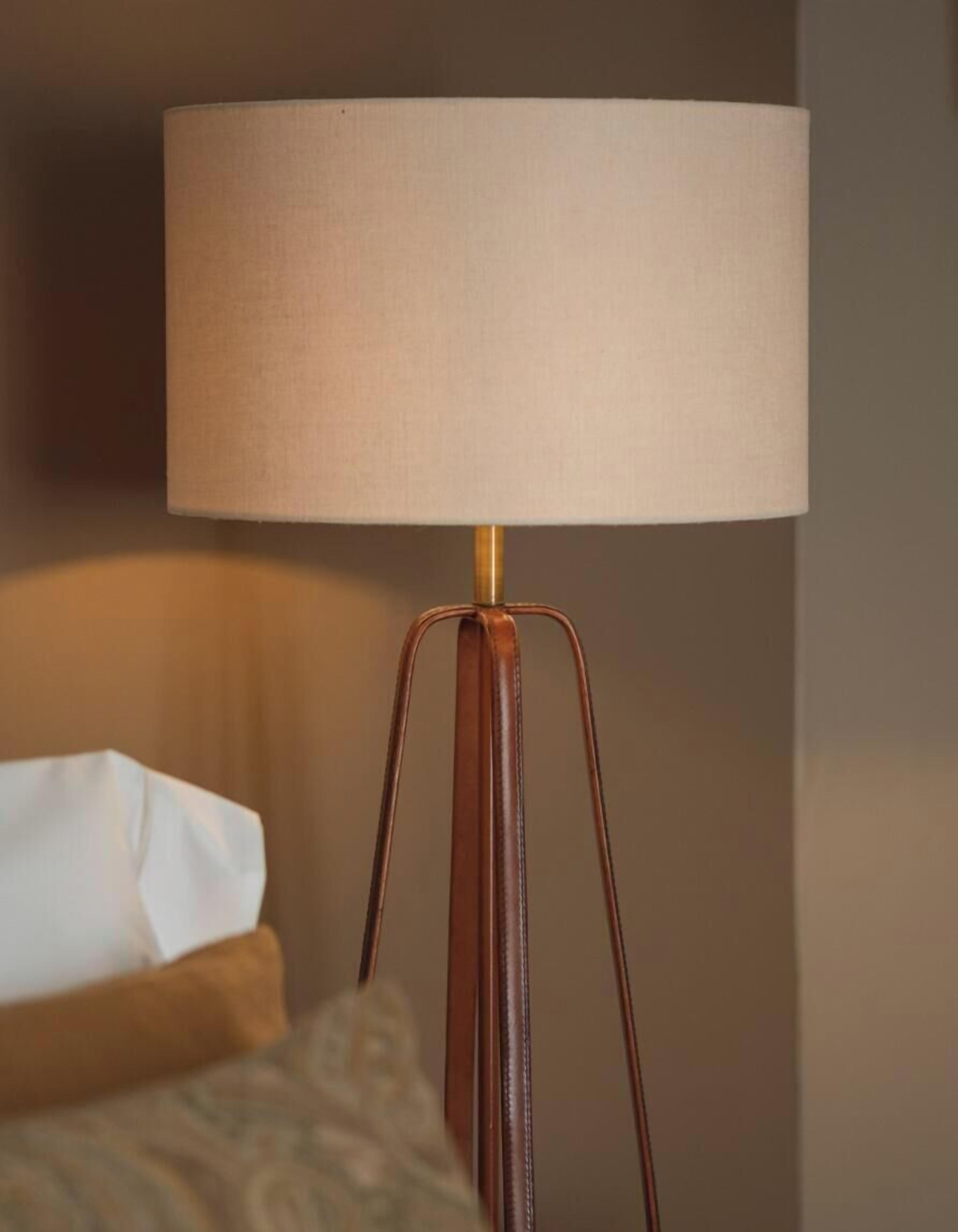 Una lámpara con pantalla color beige y base marrón.