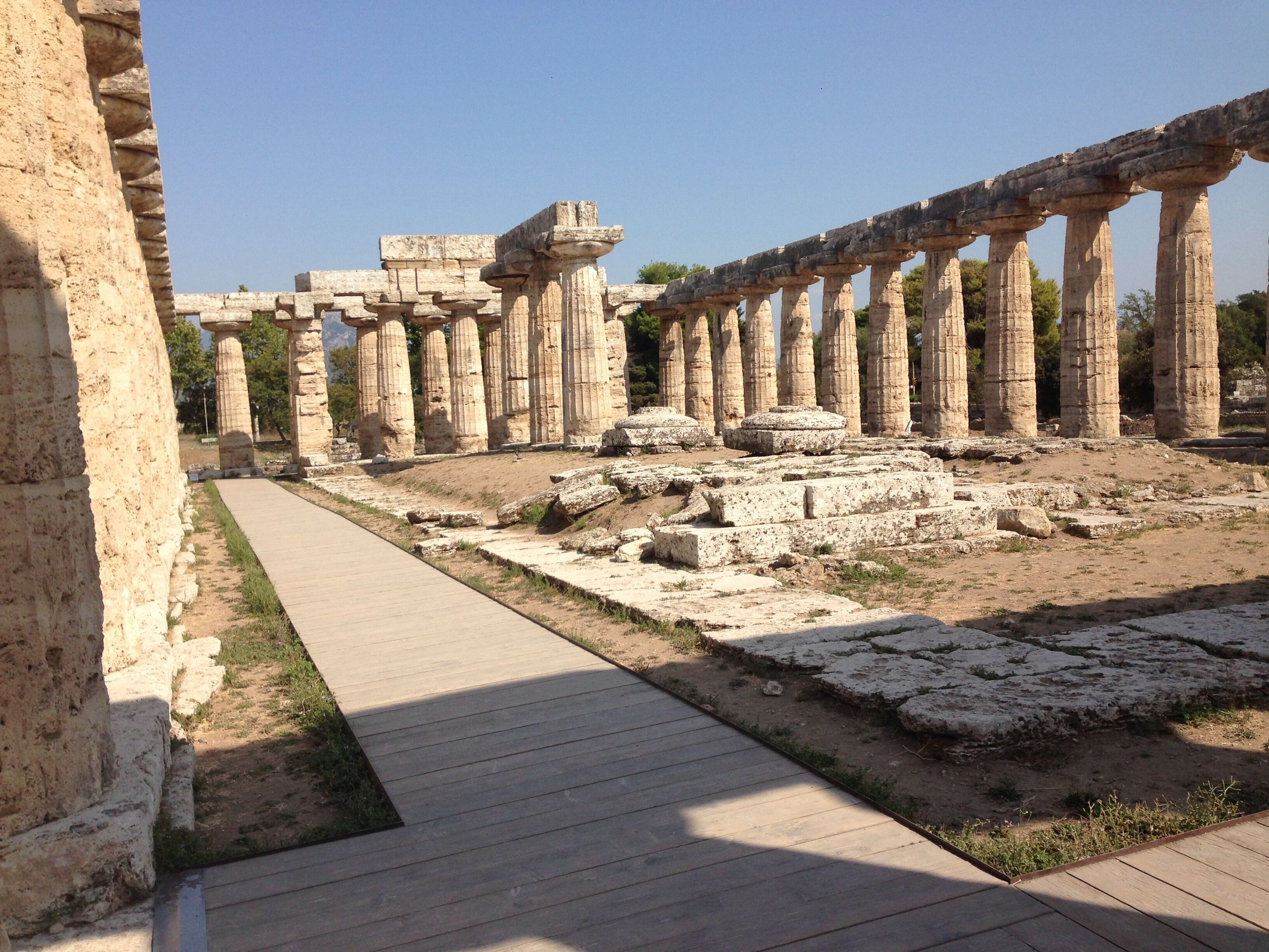 Ancient stone columns and ruins with a paved walkway.