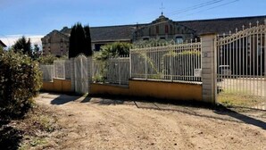 A gated property with a dirt driveway leading to a building with a tiled roof. - House in former wine estate (BEZIERS)