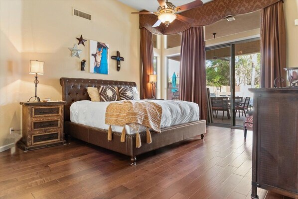 Relax in this inviting bedroom with a large bed, nightstand, and dresser, plus a balcony with outdoor seating.