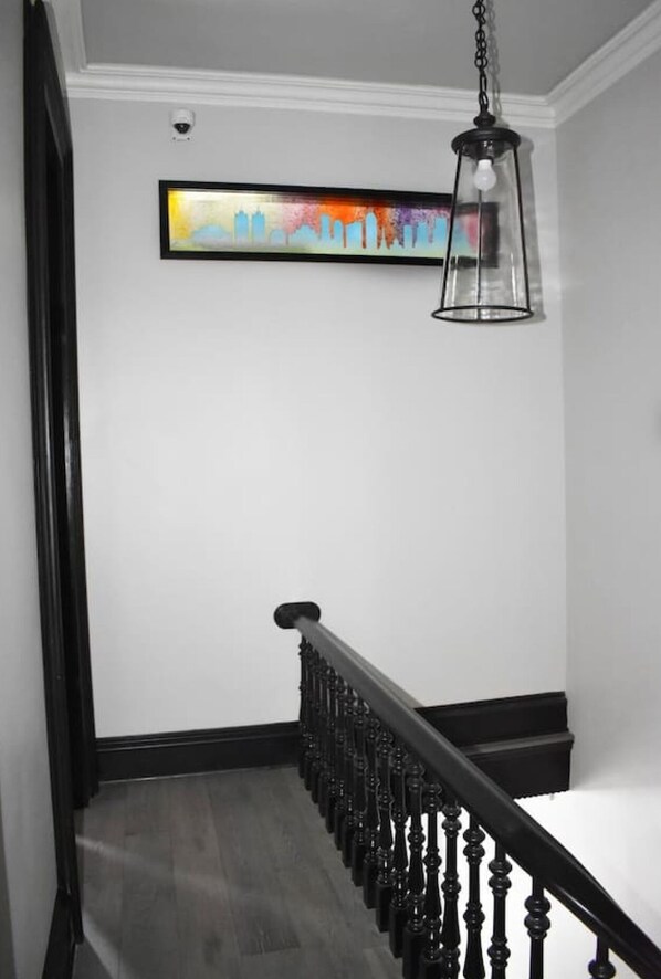 A staircase with a black railing and a hanging light fixture.