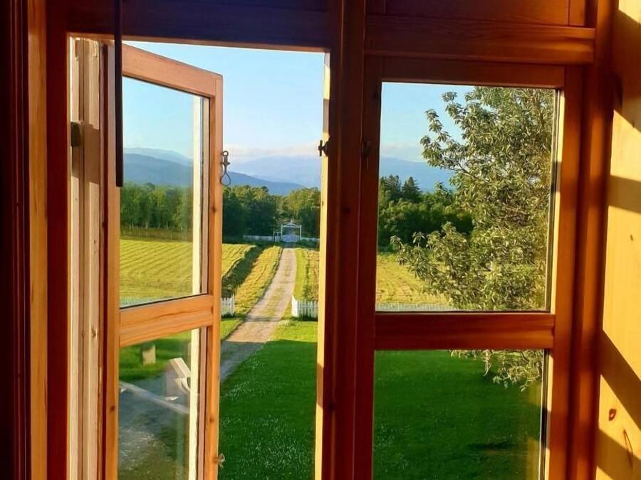 Una habitación con un ventanal grande que muestra un paisaje con césped y un sendero.