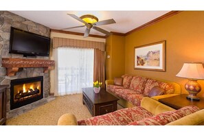 Cozy living room with a fireplace, flat-screen TV, and comfortable sofa set.
