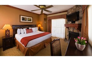 Relax in this cozy space with a large bed, flat-screen TV, and stone fireplace.