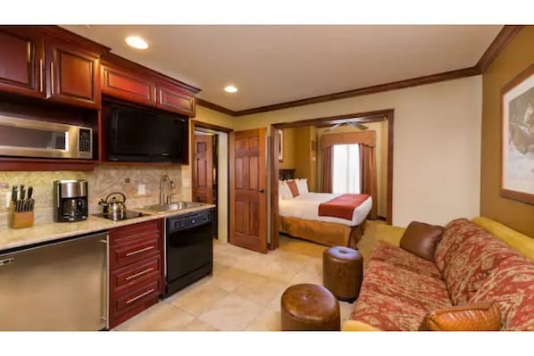Enjoy a home away from home with a kitchenette, comfortable seating, and a cozy bed.