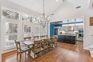 A spacious kitchen with modern appliances and a dining area with wooden furniture.