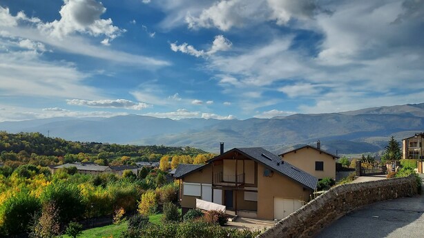 A residential area with houses, a stone wall, and a view of distant mountains under a partly cloudy sky. - Charming holiday rental apartment in the beautiful Pyrenees of France (Err)