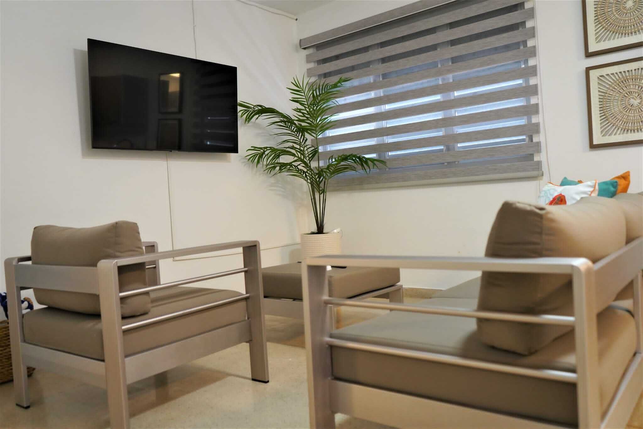 A modern living room with a sofa, a coffee table, and a TV mounted on the wall.