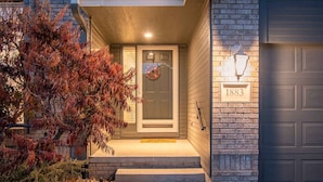 A house with a front door, a number plaque, and a garage door.