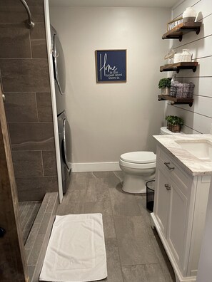 Enjoy a clean and minimalist bathroom with a toilet, shower area, and ample storage.