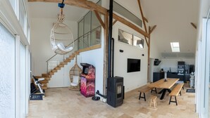 A modern kitchen with a large wooden table, a built-in stove, and a dining area with benches.
