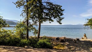 A lakeside view with a wooden dock, trees, and a clear sky. - Skipping Stone Lake House, Skipping Stone Lake House (Woods Bay)
