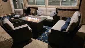 A cozy outdoor seating area with a fire pit, cushioned chairs, and a sofa. - Spacious Open Concept w/pool for Spring Training, golf and leisure!! (Peoria)