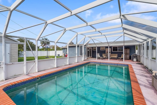 Une piscine couverte à l’eau d’un bleu limpide, entourée d’une structure en métal blanc.