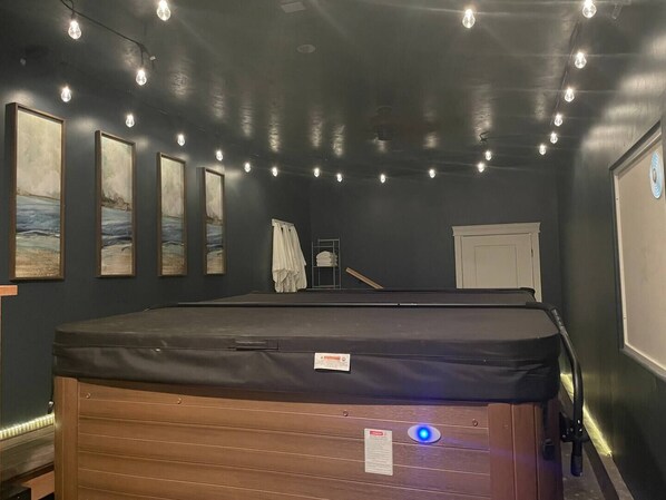 A room with a massage table, framed artwork on the wall, and a door with a window.