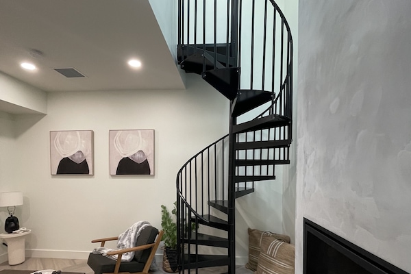 Living room with gas burning fire & spiral staircase to additional sleeping loft