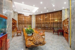 A room with a marble floor, a central table with chairs, a decorative animal head, and a fish tank.