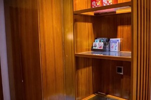 Un interior de madera con una máquina expendedora y un estante pequeño.