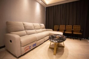 A living room with a sofa, a coffee table, and a row of chairs.