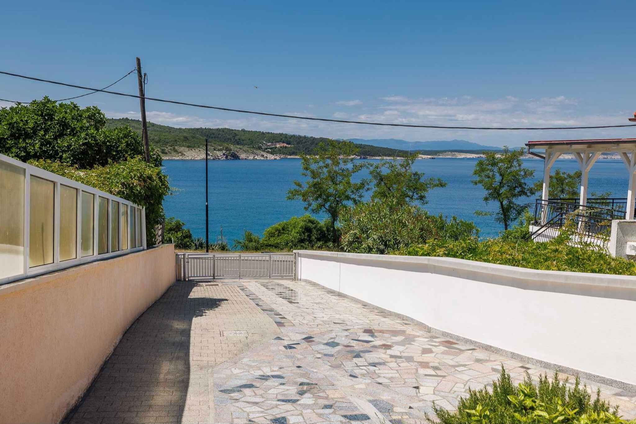 Un paseo marítimo con vistas al mar, un mirador y un edificio de fachada blanca.