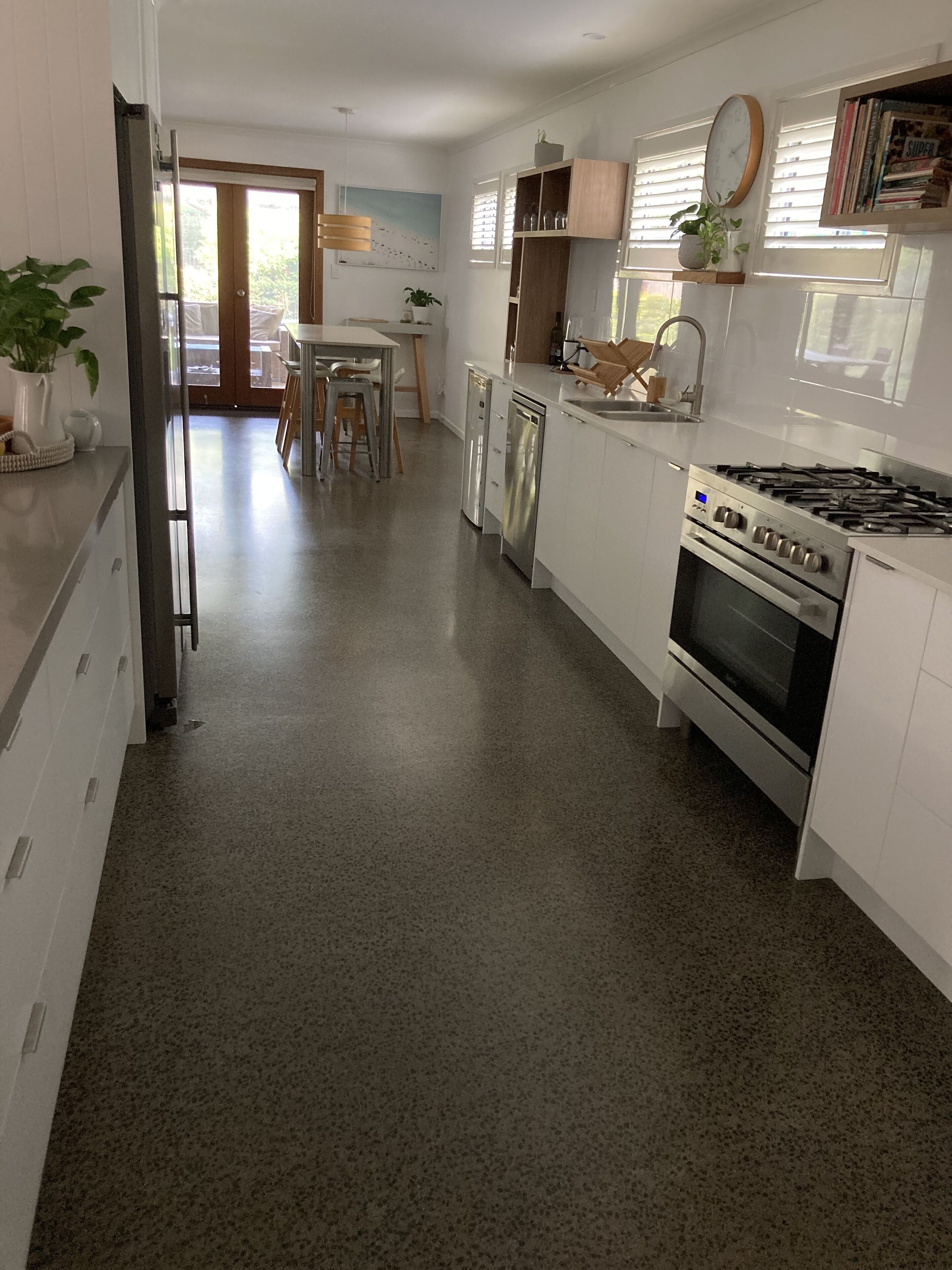 Una cocina moderna con armarios blancos, una estufa de acero inoxidable y un lavavajillas.