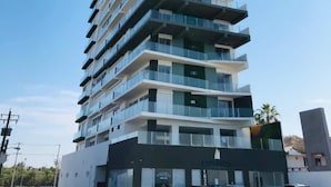 A tall, modern building with multiple balconies and large windows. - Condos Portico (Mazatlán)