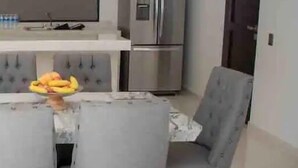A modern kitchen with a dining table, chairs, a refrigerator, and a flat-screen TV. - Condos Portico (Mazatlán)
