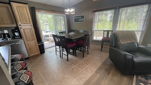 A kitchen with a dining area, a black leather chair, and a view of the outdoors. - Trailer & Parking Friendly, 24x56  Garage, 5-bedroom, 3-bath, Newly renovated! (Lead)