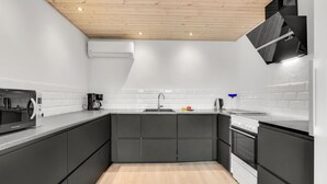 A compact kitchen with a built-in microwave, coffee maker, sink, and stove. - Nice home in Rudkøbing with kitchen (Rudkøbing)
