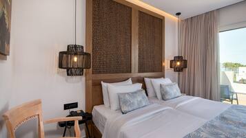 A hotel room with a bed, two bedside lamps, a chair, a desk with a phone, and a view of the outdoors.