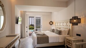 Een slaapkamer met een bed, nachtkastjes, een spiegel en een televisietoestel.