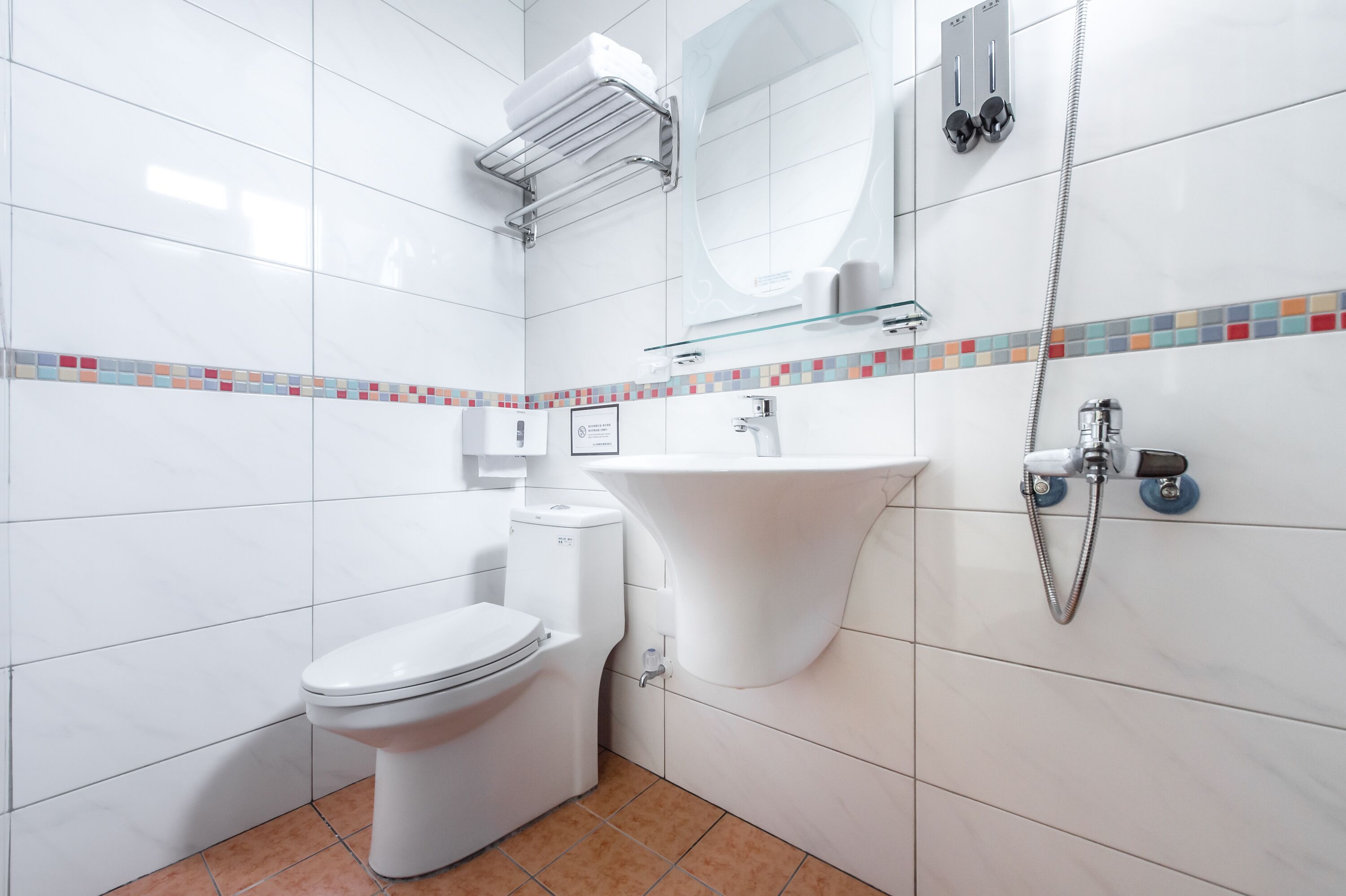 A modern bathroom with a toilet, sink, and shower.
