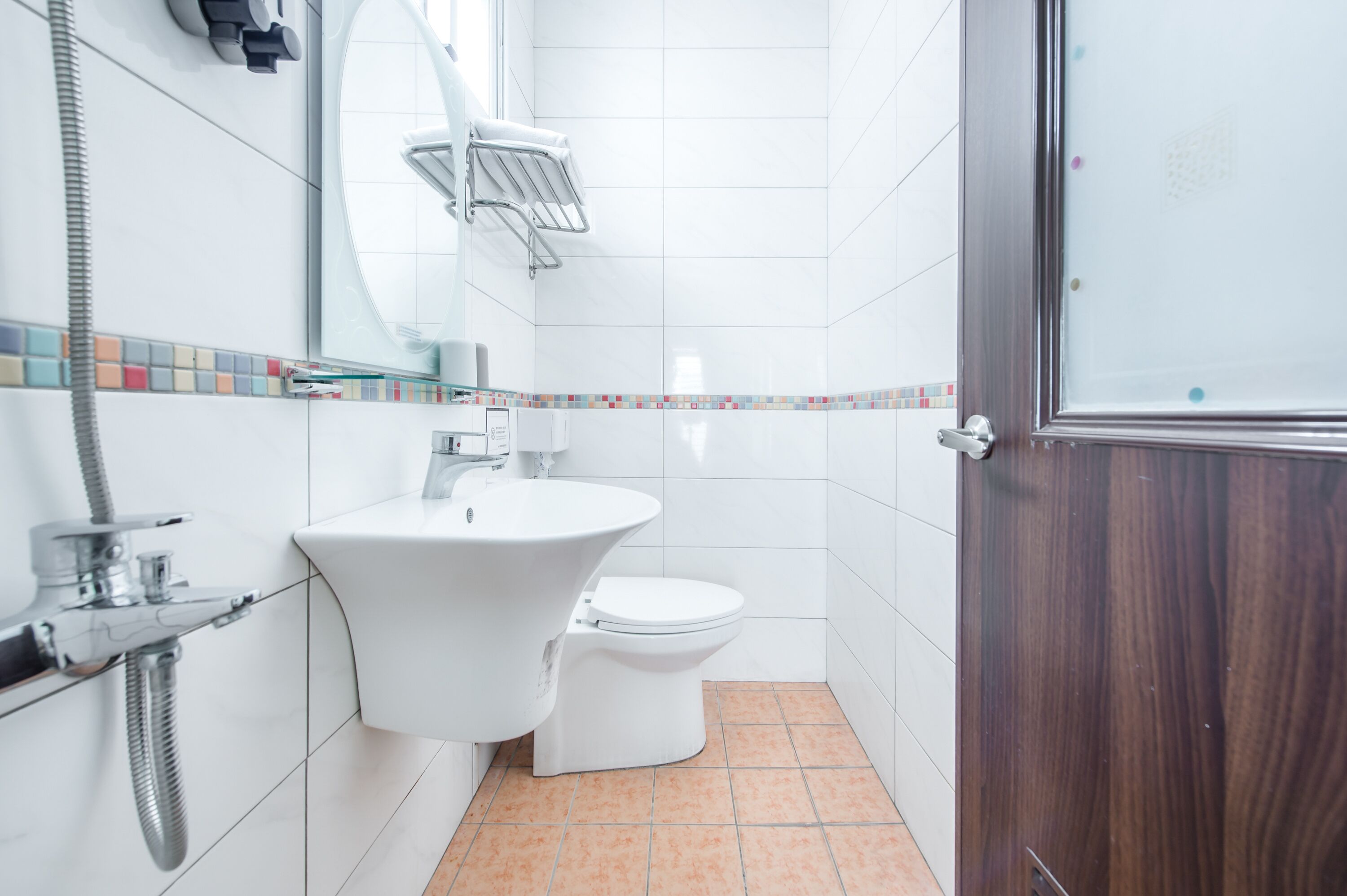 A bathroom with a white sink, toilet, and shower.