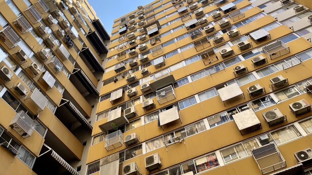 A high-rise residential building with multiple balconies, air conditioning units, and a clear sky. - Impact Muangthong Condo C3 by Miles (Pak Kret)