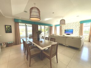 A spacious living area with a dining table, chairs, a sofa, and a television. - Lake House - Private Pool - King Bed - Sleeps 14 (Buenaventura, El Chirú)