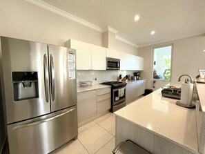 A modern kitchen with stainless steel appliances, white cabinetry, and a large window providing natural light. - Lake House - Private Pool - King Bed - Sleeps 14 (Buenaventura, El Chirú)