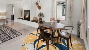 A dining area with a round table, chairs, a fireplace, and a deer head mounted on the wall. - Third & Lake - Downtown Sandpoint (Sandpoint)