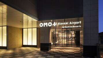 The entrance to OMO Kansai Airport by Hoshino Resorts with a checkered floor pattern.