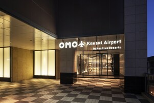 The entrance to OMO Kansai Airport by Hoshino Resorts with a checkered floor pattern.