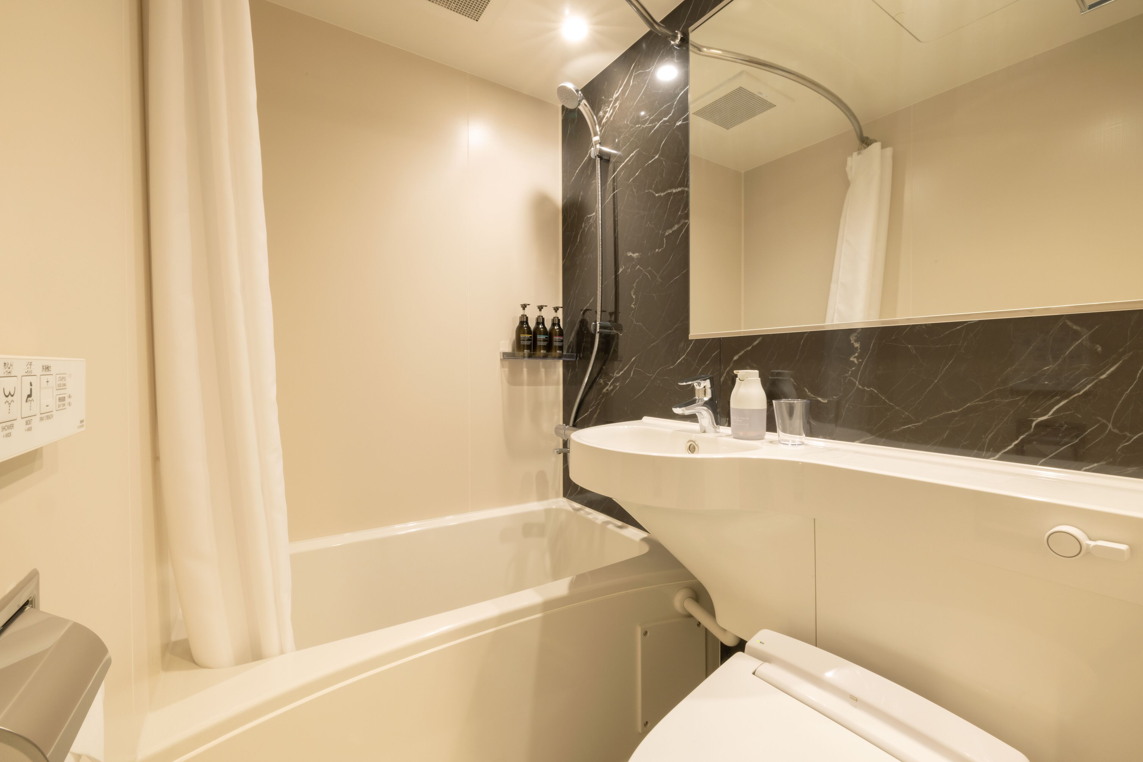 A modern bathroom with a bathtub, a sink, and a large mirror.