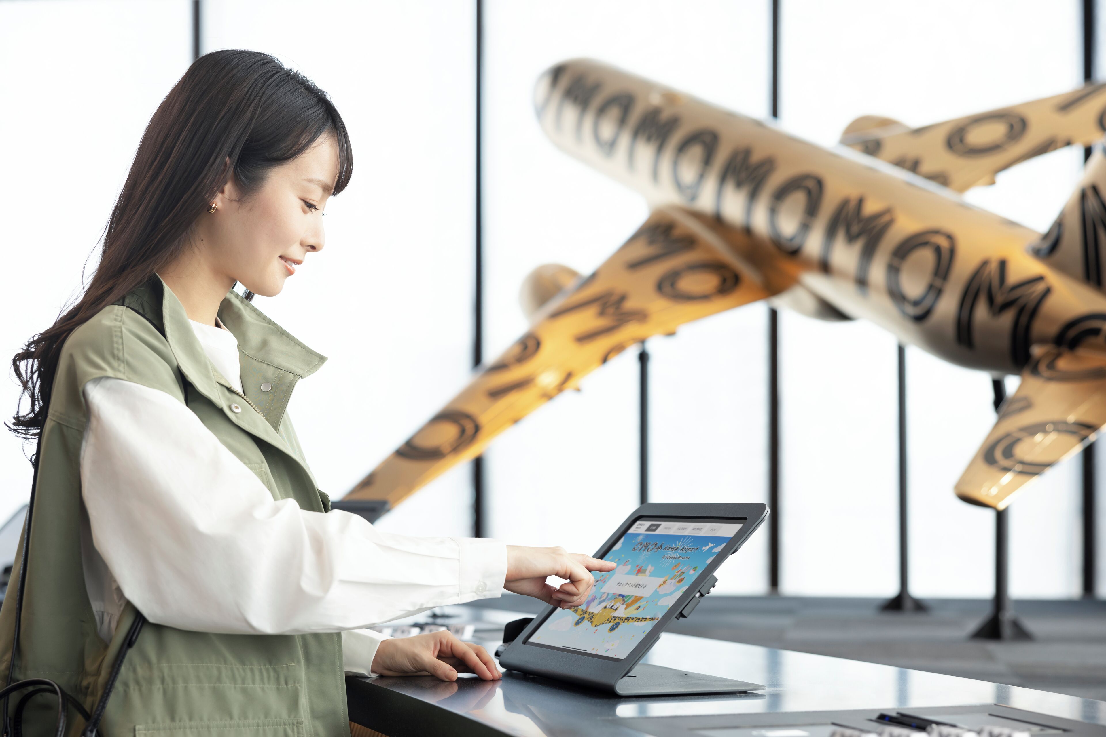 A person using a laptop at a desk with a large airplane model in the background.