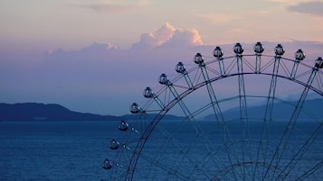 A Ferris wheel with a clear view of the water and distant mountains.