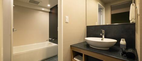 Un baño moderno con bañera, lavabo y tocador con estantes.