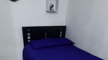 Un dormitorio con cama, cabecera de madera y un reloj de pared.