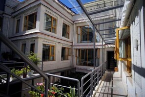 A multi-story building with large windows and a balcony. - Fengma Feiyang Hostel (Lhasa)