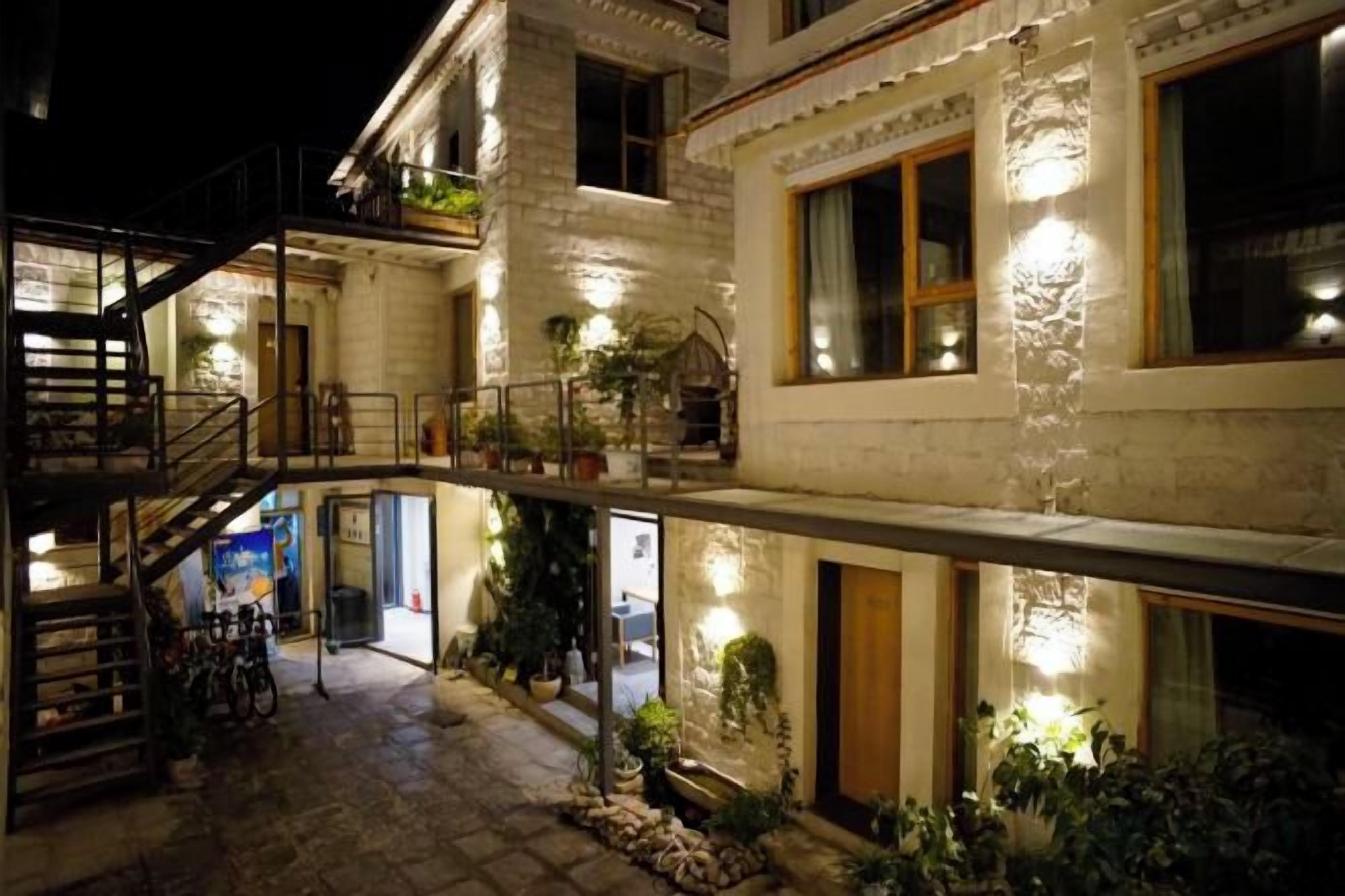 A multi-story building with a staircase, balconies, and outdoor lighting.