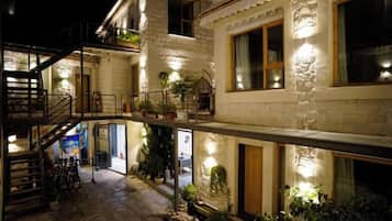 A multi-story building with a staircase, balconies, and outdoor lighting.